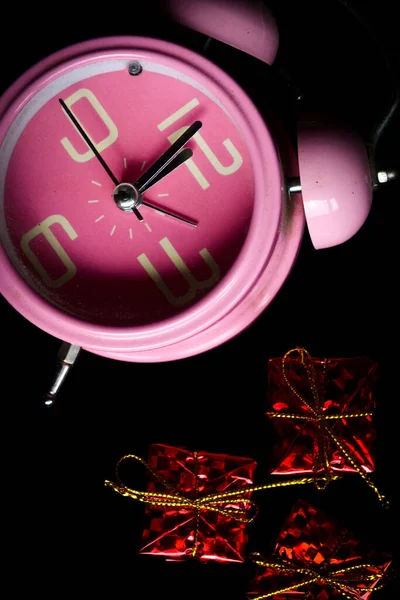 Relógio Alarme Rosa Com Uma Pequena Caixa Presente Fundo Preto — Fotografia de Stock