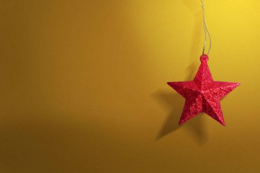 Renkli arka planda asılı kırmızı Noel süsü. Mutlu Noeller.