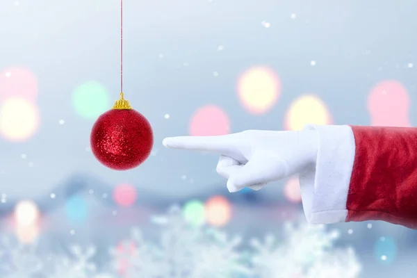 Święty Mikołaj Wskazując Czerwoną Piłkę Świąteczną Rozmytym Tle Światła Wesołych — Zdjęcie stockowe