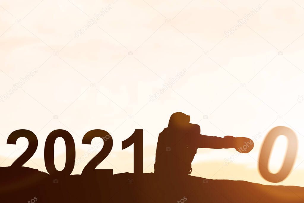 Silhouette of businessman changing 2020 to 2021. Happy New Year 2021