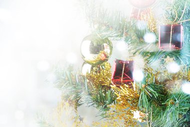 Arkaplanı bulanık, renkli bir süsü olan Noel ağacı.