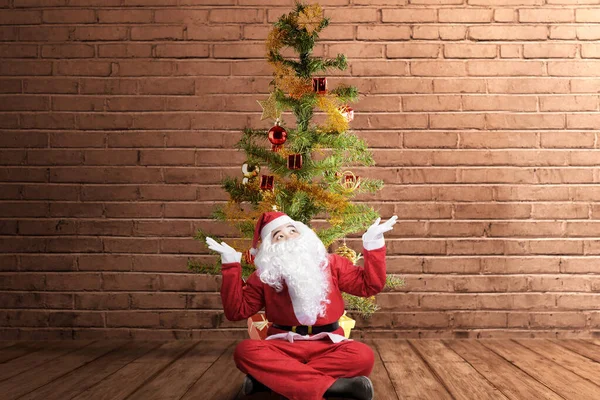 Азіат Костюмі Санти Відкритим Пальмовим Жестом Сидить Різдвяним Деревом Цегляним — стокове фото