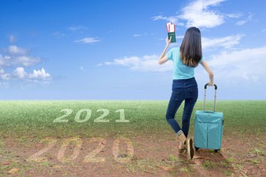 2021 'e giden bilet ve pasaportlu Asyalı bir kadının arka görüntüsü. Mutlu yıllar 2021