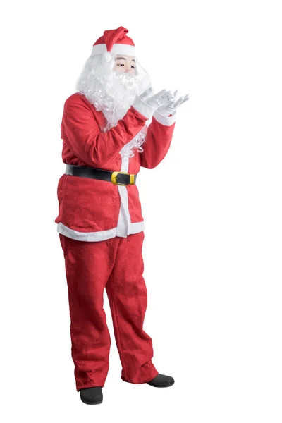 サンタの衣装のアジア人男性何かを吹く彼の手に隔離された白い背景 — ストック写真