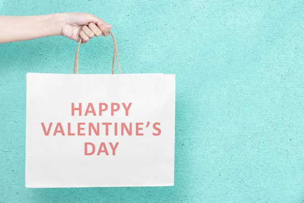 Menselijke Hand Houden Boodschappentassen Met Een Gekleurde Achtergrond Valentijnsdag — Stockfoto