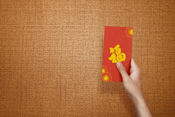 手拿着有纹理背景的红色信封 Angpao 新年快乐 — 图库照片