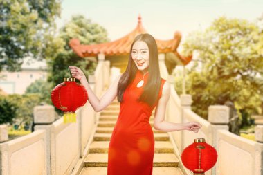Çin feneri tutan keongsam elbiseli Asyalı bir Çinli kadın. Mutlu Çin Yeni Yılı