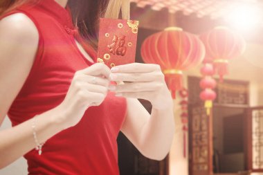 Kırmızı zarflar taşıyan Cheongsam elbiseli Çinli bir kadın. Mutlu Çin Yeni Yılı