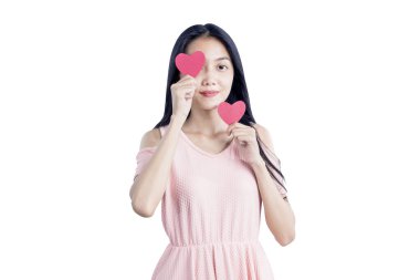 Beyaz arka planda kırmızı kalp taşıyan Asyalı kadın.