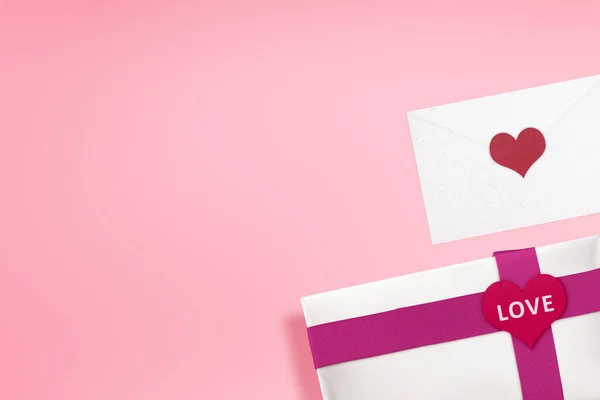 赤いリボンとハートの形をしたホワイトのギフトボックスには Loveの文字と背景が色鮮やかな封筒が入っています バレンタインデー — ストック写真