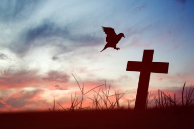 Hıristiyan haçı ve güvercin silueti gündoğumunda gökyüzü arka planında