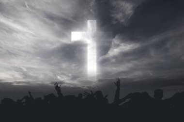 Silhouette of people looking at Christian cross with a dramatic sky background clipart