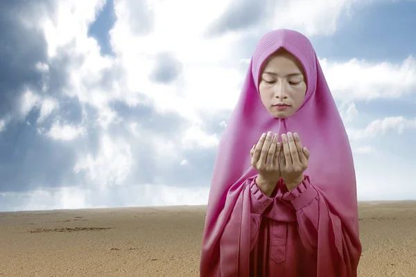 青い空を背景に手を挙げ祈りながら立ち上がるベール姿のアジア系ムスリム女性 — ストック写真
