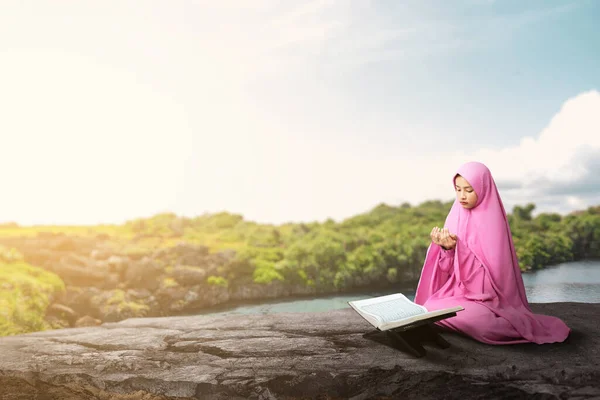 ベールに座って手を上げながら屋外で祈るアジアのイスラム教徒の女性 — ストック写真