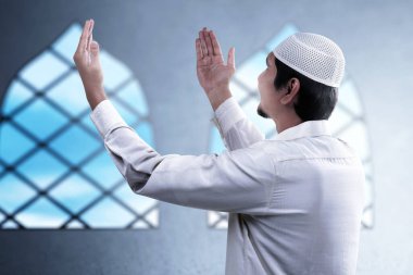 Asyalı Müslüman adam el kaldırdı ve camiye dua etti.