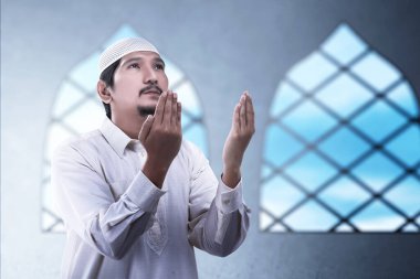 Asyalı Müslüman adam el kaldırdı ve camiye dua etti.