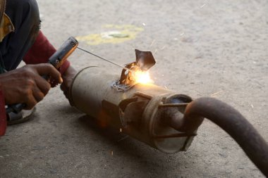 Bir işçi atölyedeki egzozu kaynaklıyor.