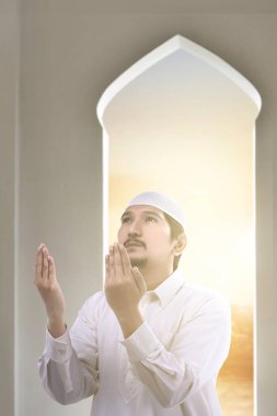 Asyalı Müslüman adam el kaldırdı ve camiye dua etti.