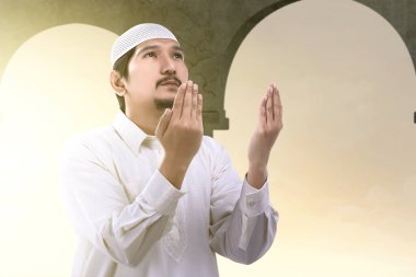 Asyalı Müslüman adam el kaldırdı ve camiye dua etti.