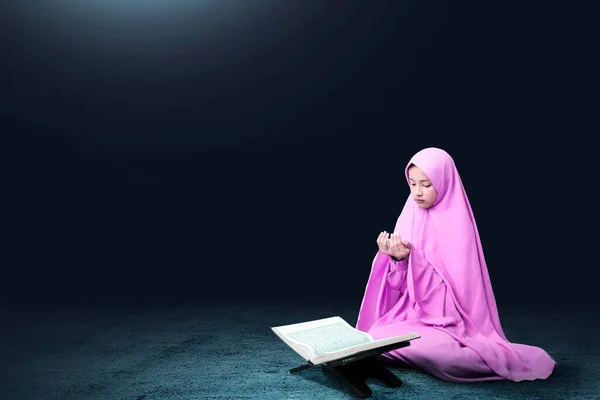 手を上げながらベールに座って暗い背景で祈るアジアのイスラム教徒の女性 — ストック写真