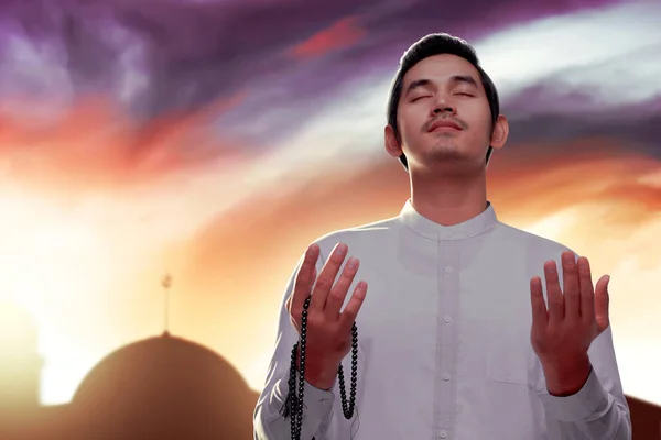 Muzułmanin Azjatycki Modli Się Paciorkami Rękach Dramatycznym Tle Nieba — Zdjęcie stockowe