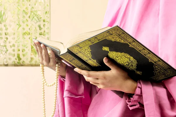 礼拝用の玉を持ったベールに身を包んだムスリム女性とモスクのクルアーン — ストック写真