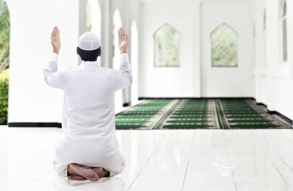 亚洲穆斯林男子举手坐在清真寺祈祷时的后视镜 — 图库照片