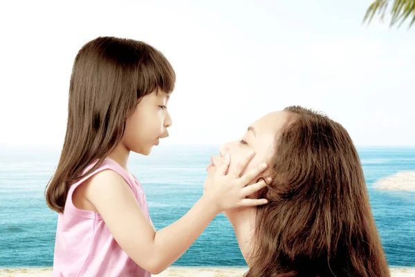 在蓝天背景的海滩上和小女孩玩耍的亚洲妈妈 — 图库照片
