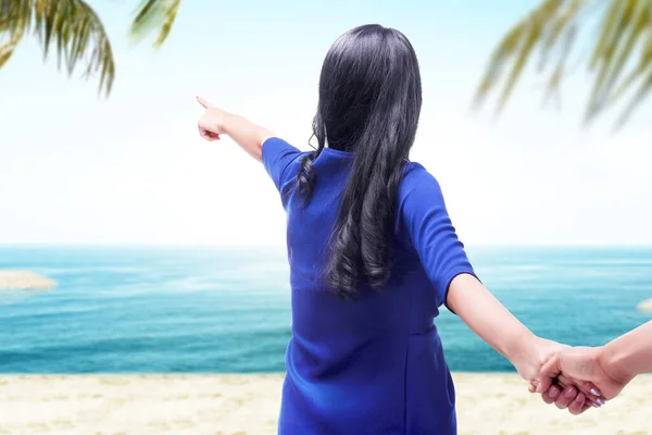 Widok Tyłu Azji Kobieta Trzyma Jej Chłopak Ręce Plaży Wskazując — Zdjęcie stockowe