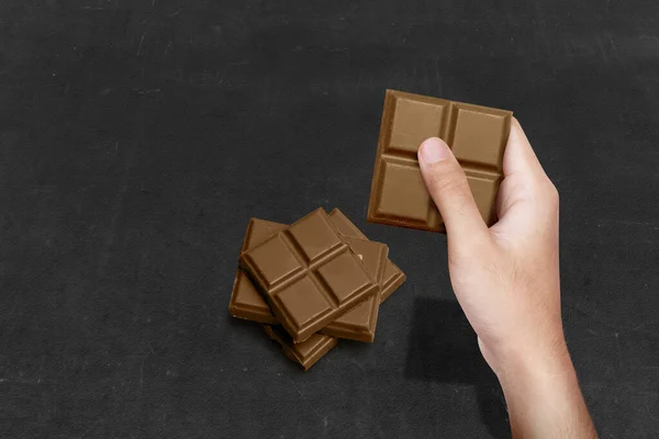 Mano Humana Sosteniendo Barra Chocolate Con Fondo Negro —  Fotos de Stock