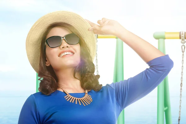 青い空を背景にビーチに帽子とサングラスを身に着けているアジアの女性 — ストック写真