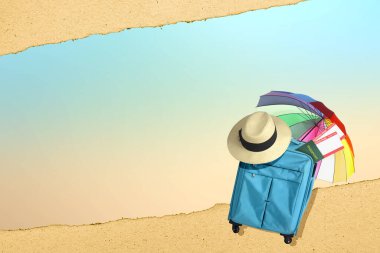 Mavi bavul, şapka, bilet ve parlak arka planlı bir şemsiye.