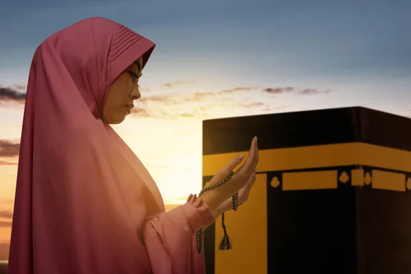 ベール立っているとカアバビューと日没シーンの背景と祈りのビーズで祈るアジアのイスラム教徒の女性 — ストック写真