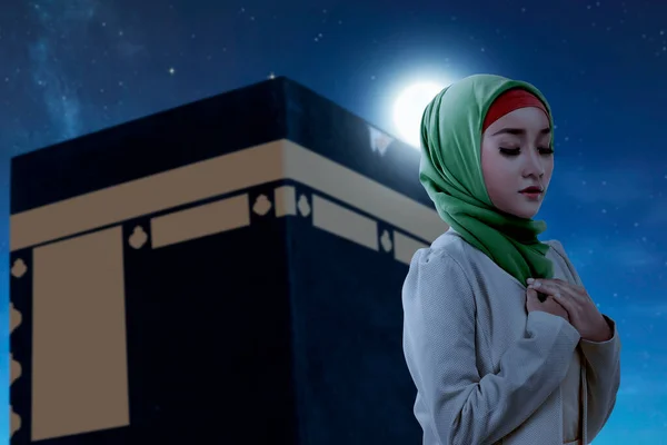 ベール立っているとカアバビューと夜のシーンの背景で祈るアジアのイスラム教徒の女性 — ストック写真