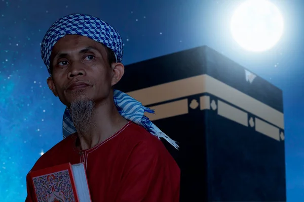 Hombre Musulmán Asiático Sentado Sosteniendo Corán Con Vista Kaaba Fondo — Foto de Stock