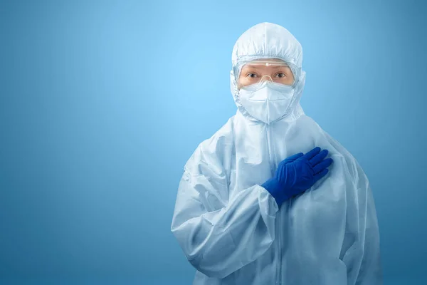 青い背景を持つ保護スーツと手袋を身に着けている健康労働者の女性 — ストック写真