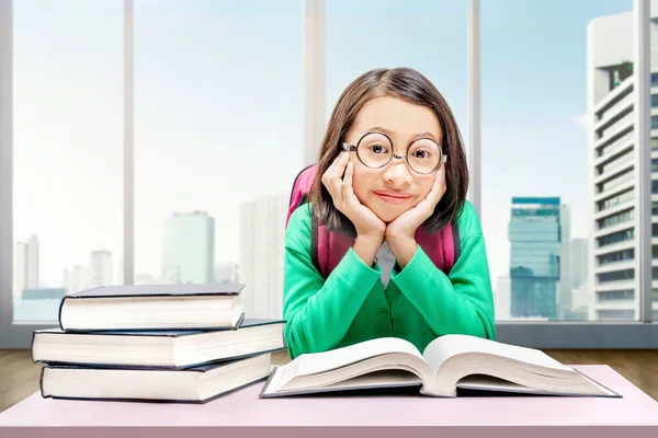 眼鏡をかけたアジア系の少女が本を家で読んでいる 学校のコンセプトに戻る — ストック写真