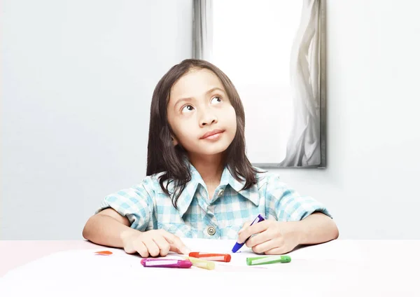 テーブルの上に紙にクレヨンの絵を描くアジア系の少女 学校のコンセプトに戻る — ストック写真