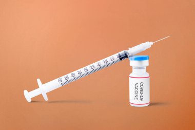 Renkli arka planı olan şırınga ve covid 19 aşı.