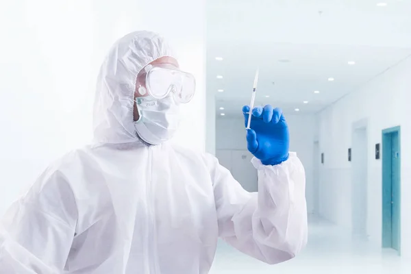 病院で保護服と手袋保持注射器を持つ健康労働者の男 — ストック写真