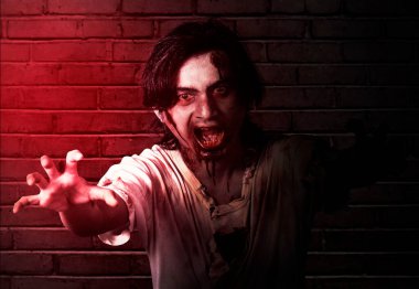 Korkunç bir zombi. Vücudunda kan ve yara var. Terk edilmiş binada duruyor.