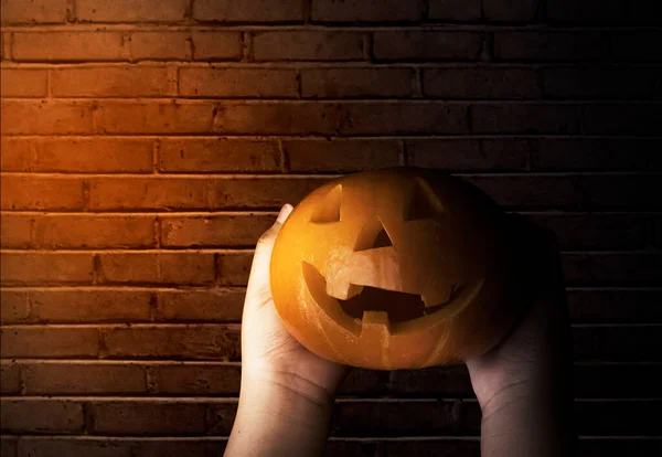 Χέρι Κρατώντας Jack Lantern Φόντο Τούβλο Τοίχο — Φωτογραφία Αρχείου