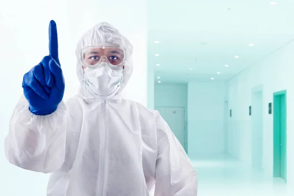 保護服と手袋を着た健康労働者が病院でジェスチャーを指摘して立っている — ストック写真