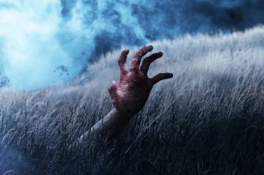 Çayırda yaralı ve kanlı zombi eli.