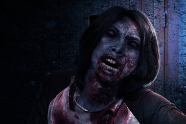 Korkunç bir zombi. Vücudunda kan ve yara var. Terk edilmiş binada duruyor.