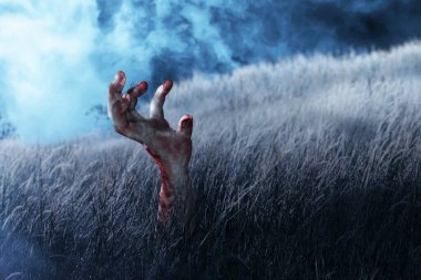 Çayırda yaralı ve kanlı zombi eli.