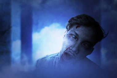 Korkunç bir zombi. Vücudunda kan ve yara var. Terk edilmiş binada duruyor.