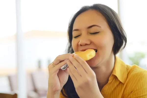 Donna attraente mangiare ciambella al caffè — Foto Stock