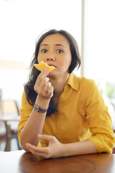 Atractiva mujer comiendo donut en el café —  Fotos de Stock