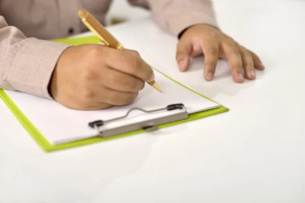 Hombre escribiendo en papel en blanco en portapapeles —  Fotos de Stock